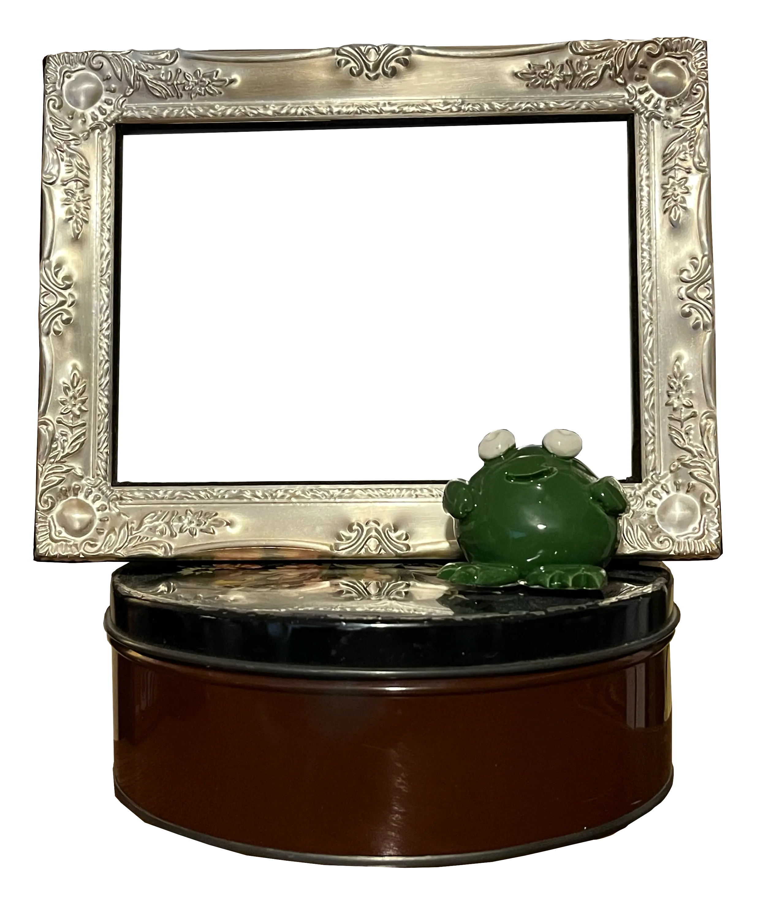 a png of a metal picture frame sitting on a round tin container
